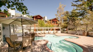 A backyard with a swimming pool, patio furniture, and a covered seating area. - Two Pools Tennis Balcony Hiking Golf Biking Restaurants Activities Summer Perfection! (Park City)
