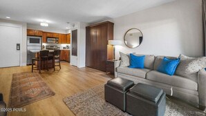 A living room with a sofa, ottoman, and a rug. - Two Pools Tennis Balcony Hiking Golf Biking Restaurants Activities Summer Perfection! (Park City)