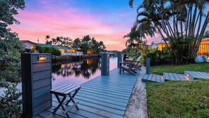 A waterfront property with a dock, lounge chairs, and a pool. - Soleil Breeze by Avantstay Pool + Canalfront Home + Outdoor Dining Canal Deck + Kayak 10 Mins to the Beach (Fort Lauderdale)