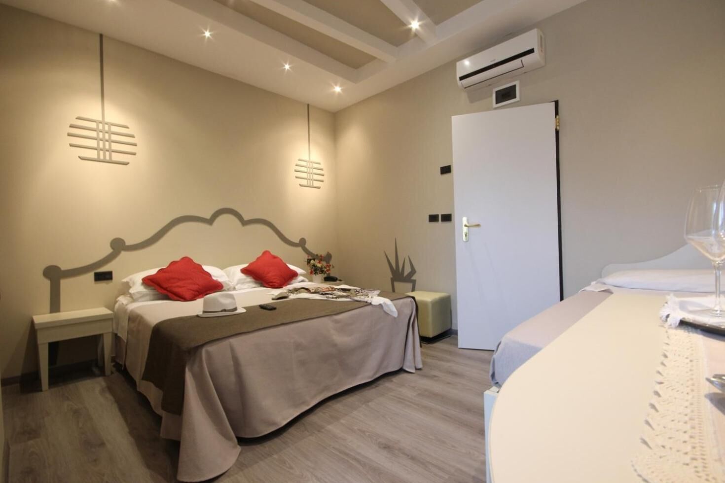 Ein Hotelzimmer mit Bett, Nachttischen, Schreibtisch, Stuhl und Klimaanlage.