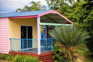Una casa colorida con un porche, una puerta y una planta grande al frente.
