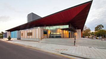 A modern building with a sloped roof, large windows, and a prominent entrance.