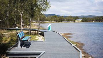 A waterfront walkway with a bench and a viewing platform.