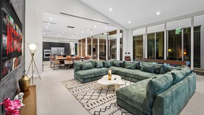 Ein moderner Wohnbereich mit Ecksofa, Couchtisch und Essbereich mit Stühlen und Tisch.