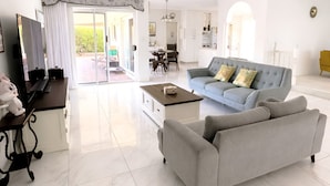 Ein modernes Wohnzimmer mit Sofa, Couchtisch und Fernseher.