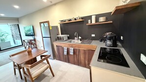 Cozinha moderna com área de jantar, eletrodomésticos embutidos e uma janela grande.