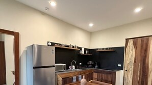 Cozinha moderna com frigorífico embutido, mesa de jantar de madeira e um armário grande de madeira.