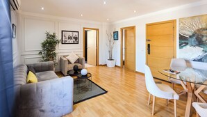 A modern living room with a sofa, chairs, a coffee table, a potted plant, and a painting on the wall. - Spot Bonheur downtown Wi-Fi Fiber + balcony (Casablanca)