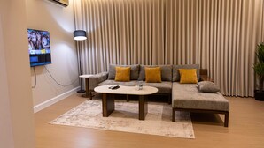 Un salon moderne avec un canapé, une table basse et un téléviseur fixé au mur.