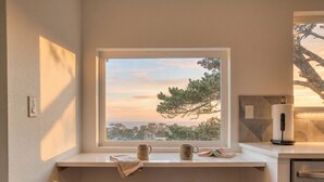 Una habitación con ventanal a un paisaje, un escritorio con una silla y un dispensador de toallas de papel.