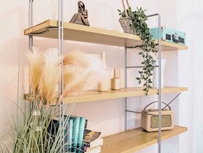 A multi-tiered metal shelf unit with decorative items and books. - 1-Bed Sheffield Flat Near Arena + Parking (South Yorkshire)