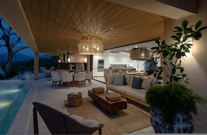 A modern living area with a pool, wooden ceiling, and a large potted plant. - Villa Monarca in Punta Mita (Punta de Mita)