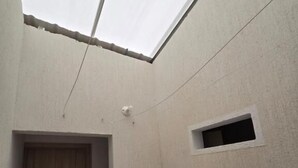 Un bany amb una finestra pintoresca, una porta de fusta, un petit finestral i un lavabo amb dosificador de sabó.