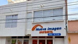 Edifici amb un cartell de 'Nueva Imagen Apartamentos' i un número de contacte.