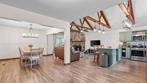 A spacious living area with a dining table, sofas, and a kitchen with modern appliances. - Owl & Ember - Walk to Coosawatee Resort Center! Grill, 2 Kings, 3 Smart TV's (Ellijay)