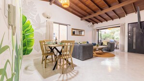 Un espacio habitable amplio con una mesa de comedor, sillas, un sofá y un ventanal grande.