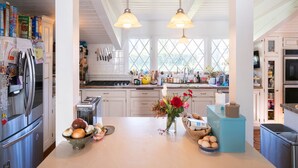 A kitchen with a central island, stainless steel appliances, and a window providing natural light. - Amazing 5-bedroom farmhouse in quaint Rolling Hills Estates with AC and nature! (Rolling Hills Estates)