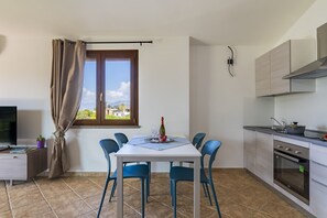 Une cuisine moderne avec une table à manger, des chaises et un téléviseur.
