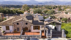 A villa with a stone facade, multiple windows, and solar panels. - Mary's Vacation Home Near the Ocean (Tortoli')