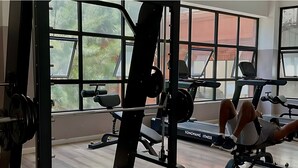 A gym with weightlifting equipment, treadmills, and large windows. - Luxury 6-Bed Penthouse with Sky Terrace (Nairobi)