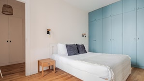 Ein Schlafzimmer mit einem Bett, einem Nachttisch, einem Kleiderschrank und zwei Wandleuchten.