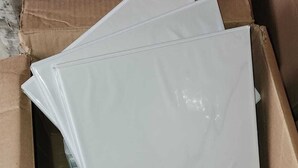 Una caja de cartón con varios objetos de plástico blanco y transparente.