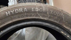 Neumático con el texto 'HYDRA EDGE TOUR' y '225/55R18 98V'.