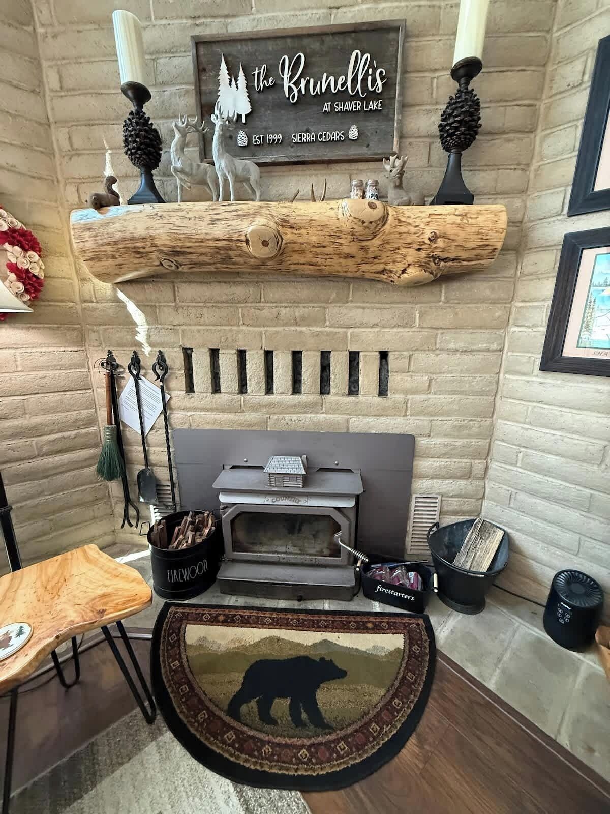 A rustic interior with a fireplace, a log shelf, and a bear rug.