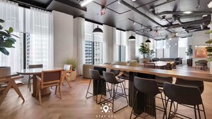 A modern office space with a long communal table, bar stools, and a meeting area with chairs. - Elite Stay with Rooftop Vibes Studio (Miami)
