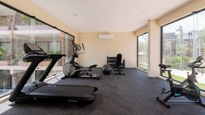 A gym with treadmills, an elliptical, and a stationary bike, with large windows and a view of the outdoors. - Modern 1-bedroom studio with Sunken Pool, AC and gym access in La Veleta, Tulum (Tulum)
