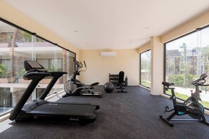 A gym with treadmills, an elliptical, and a stationary bike, with large windows and a view of the outdoors. - Modern 1-bedroom studio with Sunken Pool, AC and gym access in La Veleta, Tulum (Tulum)