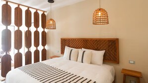 A bedroom with a bed, wooden headboard, two hanging lights, and a wall with wooden panels. - Modern 1-bedroom studio with Sunken Pool, AC and gym access in La Veleta, Tulum (Tulum)