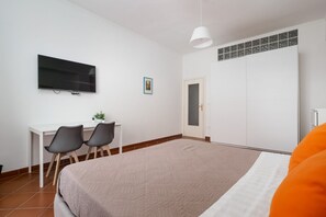 A bedroom with a bed, a desk with chairs, a television, and a wardrobe. - Panoramic Sea-View Terrace in the Quiet Beauty of the Sorrento Coast (Massa Lubrense)