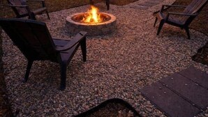 A cabin with a fire pit and outdoor seating.