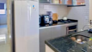 A kitchen with a refrigerator, stove, and various appliances.
