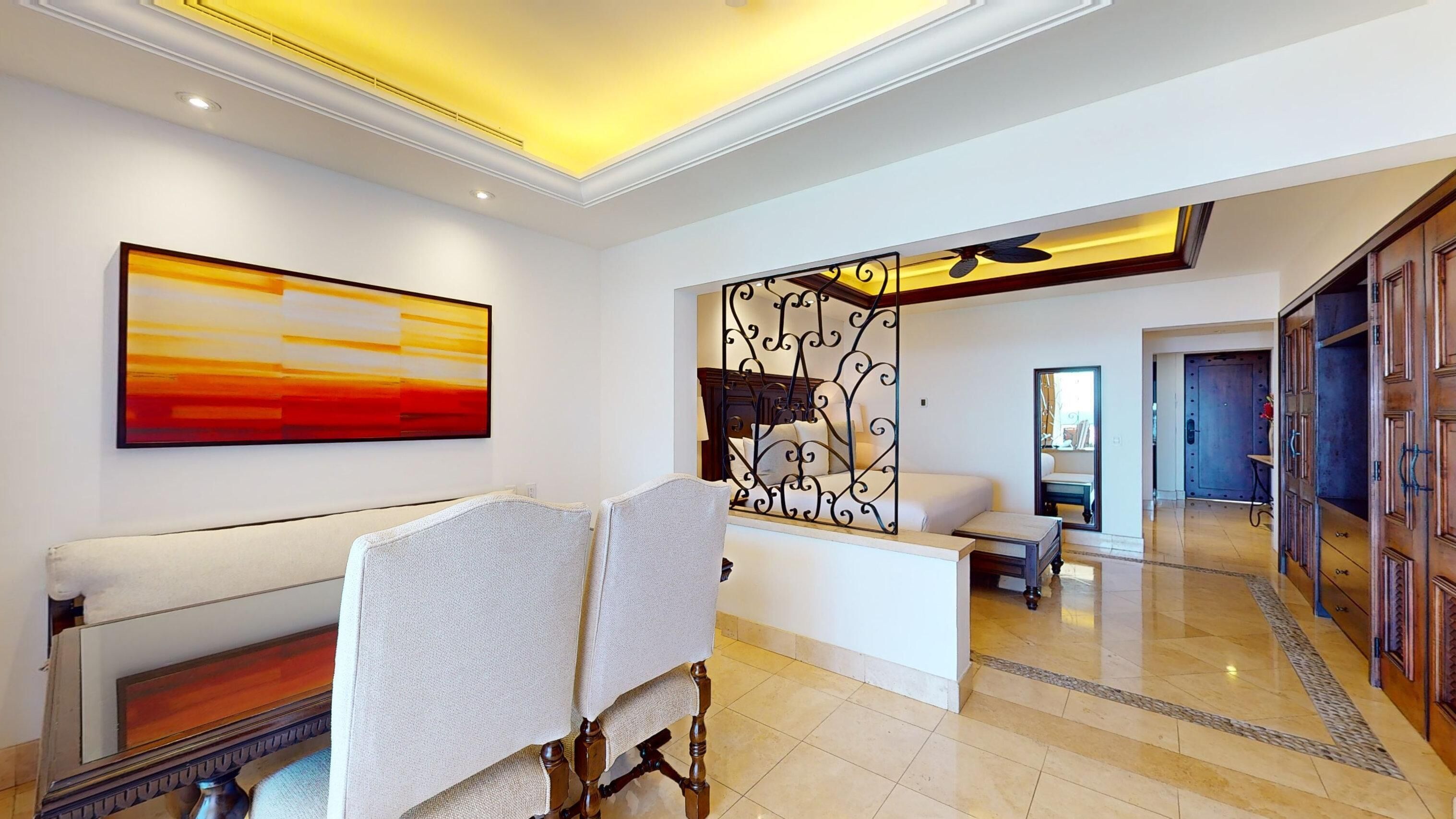 Een hotel lobby met een receptiebalie, een zithoek en een groot abstract schilderij.