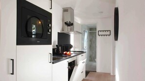 Une cuisine moderne équipée d’un four à micro-ondes, d’une machine à café et d’une fenêtre.