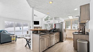 Una cucina moderna con isola centrale, mobili in legno e un'ampia finestra.