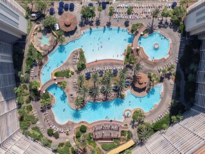 Un complejo de piscinas grande y de varios niveles, con diferentes formas y comodidades circundantes.
