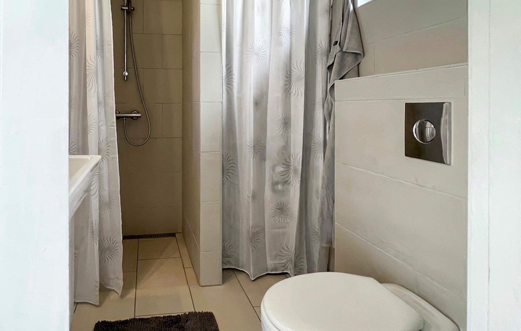 Ein Badezimmer mit Toilette, Dusche und Handtuchhalter.