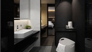 A modern bathroom with a large mirror, a white sink, a dark countertop, and a shower area. - Chengdu Suli Travel Hotel (Chengdu)