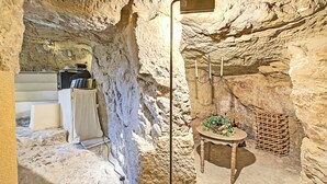 A cave-like interior with a table, books, and a small plant.