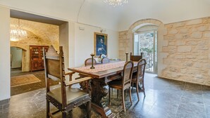 Ein Esszimmer mit Steinwand, einer Kronleuchter und Holzwandmöbeln.