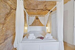 A bed with a canopy, white linens, and a book on the bed. - Borgo Hedone - Jardin, Scicli, Italy (Scicli)