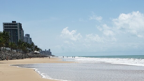 Una playa con arena y olas.