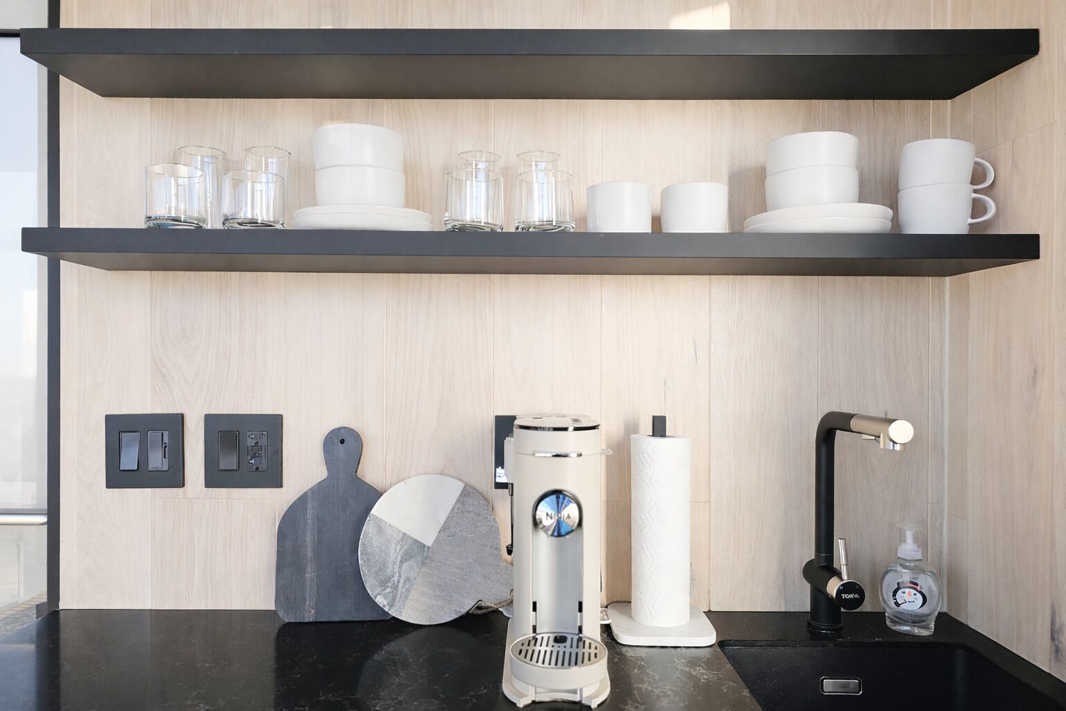 A modern kitchen with a coffee machine, a sink, and a countertop.