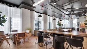 A modern office space with a long wooden table, multiple bar stools, and a high ceiling with exposed pipes. - 501 First Luxury Ocean View from Balcony Rooftop Pool & GYM 2110 (Miami)