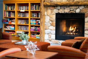 A cozy room with a fireplace, a bookshelf filled with books, and comfortable seating. - Wonderful 2-Bedroom Condo Located at Pollard Brook (Lincoln)