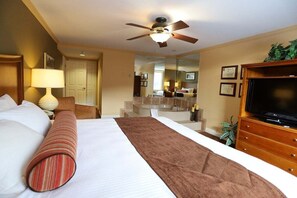 A hotel room with a bed, a television, a ceiling fan, a mirror, and a bathroom visible through an open door. - Wonderful 2-Bedroom Condo Located at Pollard Brook (Lincoln)