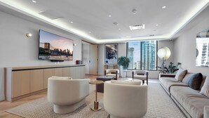 A modern living room with a flat-screen TV, comfortable seating, and large windows offering city views. - 501 First Luxury 1 BR + Den & 2 Baths Rooftop Pool & GYM 502 (Miami)